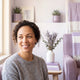 A happy woman in her 30s smiles gently, conveying trust and satisfaction.