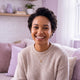 A smiling young woman with short, dark hair looks directly at the camera, conveying trust and happiness.