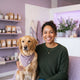 A happy woman in her 30s smiles warmly with a calm, well-groomed dog, conveying satisfaction and trust.